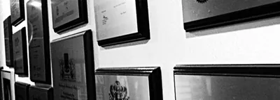 Wall of framed specialist certificates inside Lim Skin Specialist Clinic (black and white)